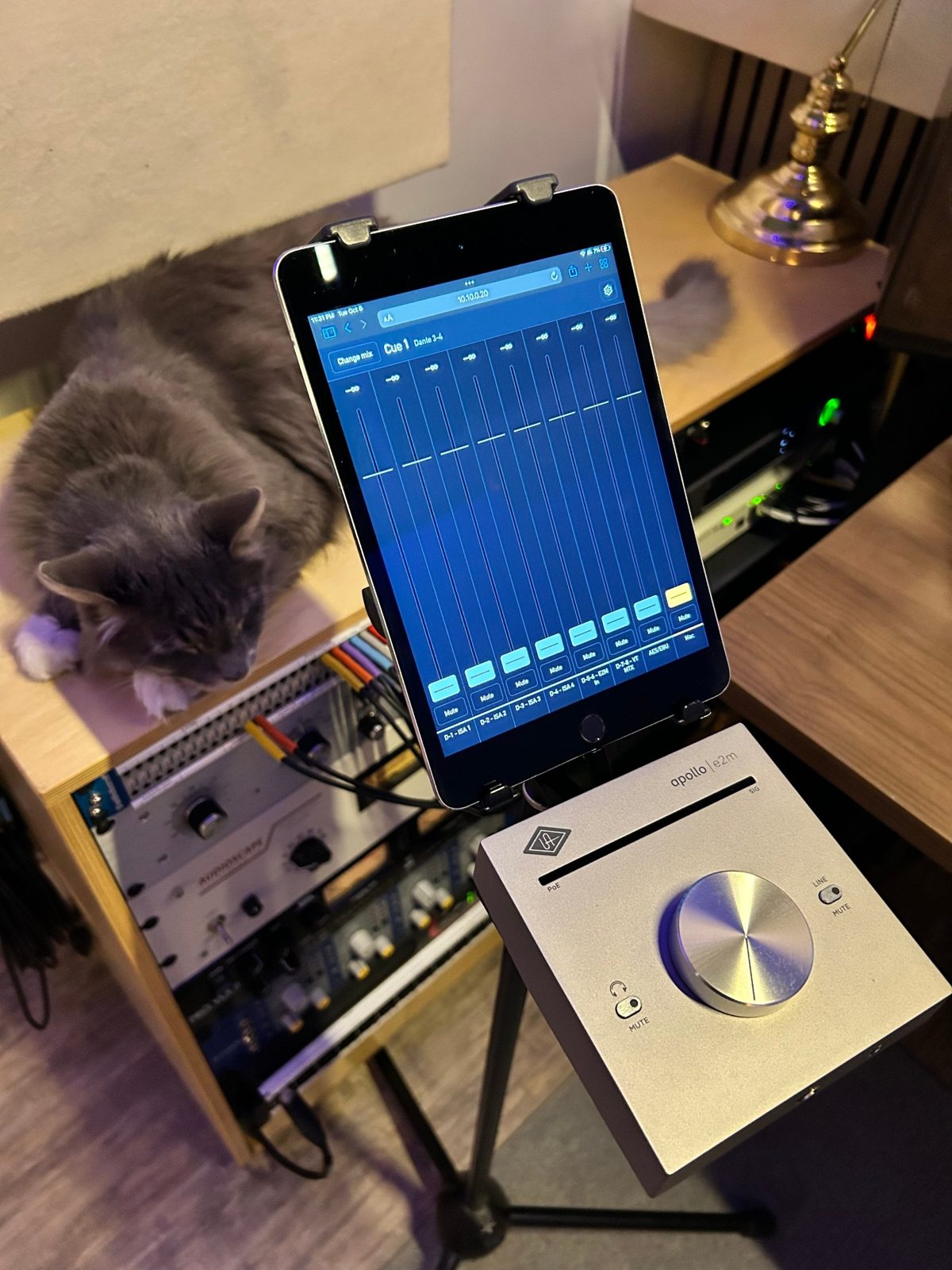 An iPad on a mic stand showing YourCue's faders for Cue 1, next to an Apollo e2m.